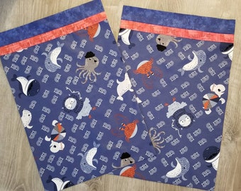 Travel or toddler pillowcase in blue fabric featuring creatures of the sea with red and blue trim at opening