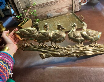 Brass duck wall hanging five on log