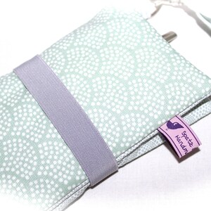 May include: A light green fabric pouch with white polka dots, a gray elastic band, and a purple tag that says "Spotte Handmade".
