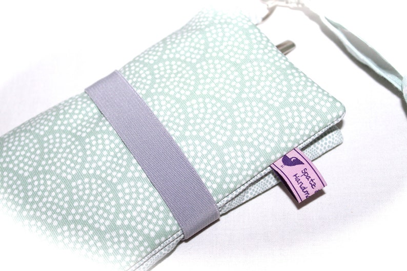 May include: A light green fabric pouch with white polka dots, a gray elastic band, and a purple tag that says "Spotte Handmade".