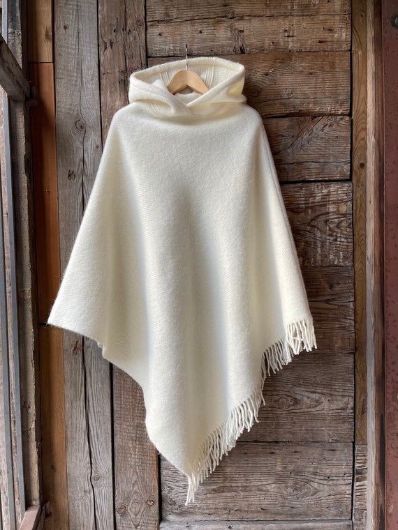 Poncho largo de lana de cordero con capucha y flecos de color blanco leche para mujer