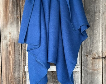 May include: A blue fleece blanket hanging on a wooden ladder. The blanket is folded in half and has a soft, fuzzy texture.