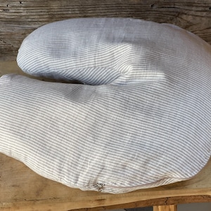 May include: A gray and white striped pregnancy pillow with a zipper closure.