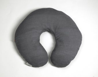 May include: A gray U-shaped pillow made of linen fabric. The pillow is designed for supporting a baby during breastfeeding or for providing comfort while sleeping.