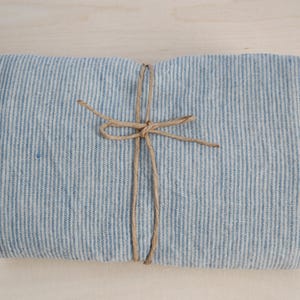 May include: A blue and white striped fabric wrapped with twine, tied in a bow.