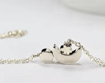 May include: A silver chain bracelet with a crescent moon charm and a small star charm.