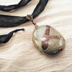 Kazuri bead pendant in green and brown on dark green fairy ribbon; tie on statement pendant; adjustable length