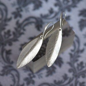 Elegant silver earrings with a hammered texture. They have a gentle centre fold.