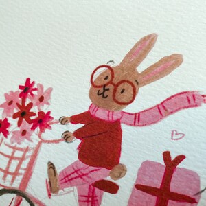 May include: A brown rabbit wearing red glasses, a red sweater, and a pink scarf rides a pink bicycle with a basket of pink and red flowers. The rabbit is carrying a pink gift box.