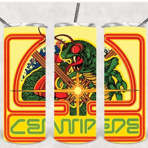 May include: A yellow tumbler with a retro arcade game design. The design features a green centipede-like creature with red eyes and a starburst, with the word "CENTIPEDE" in green. Includes a silver straw.