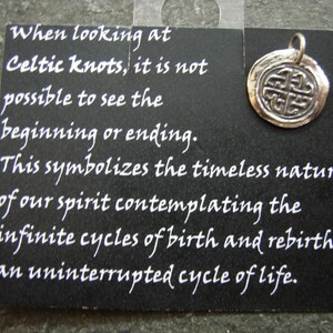 May include: A silver Celtic knot charm pendant with a black card that reads: "When looking at Celtic knots, it is not possible to see the beginning or ending. This symbolizes the timeless nature of our spirit contemplating the infinite cycles of birth and rebirth, an uninterrupted cycle of life."