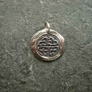 May include: Silver pendant featuring a Celtic knot design. The pendant is round and has a textured finish.