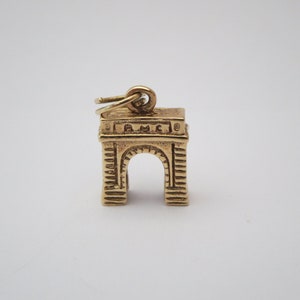Puede incluir: Encanto de color dorado con forma de Arco del Triunfo en Par&iacute;s, Francia. El encanto tiene un bucle en la parte superior para sujetarlo a un collar o pulsera.