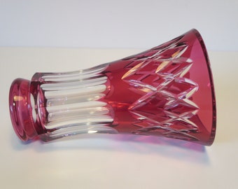 Puede incluir: Un jarrón de cristal rojo oscuro con un diseño de vidrio tallado claro. El jarrón tiene una boca ancha y una base estrecha.