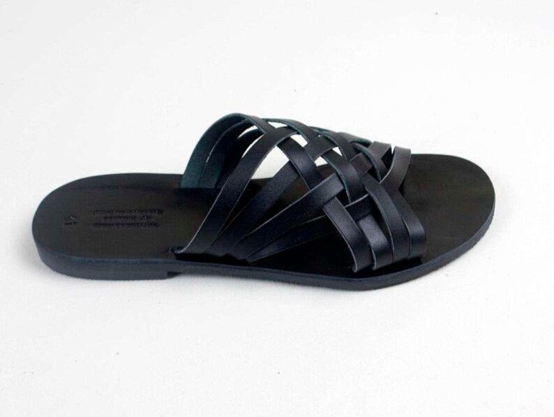 Puede incluir: Sandalias de cuero negro con un dise&ntilde;o de correas trenzadas. Las sandalias tienen una suela plana y un estilo sencillo y elegante. El dise&ntilde;o de punta abierta es ideal para el clima c&aacute;lido.