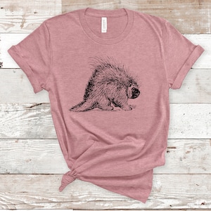 K&ouml;nnte beinhalten: Ein pinkfarbenes T-Shirt mit einer Schwarzwei&szlig;illustration eines Stachelschweins.