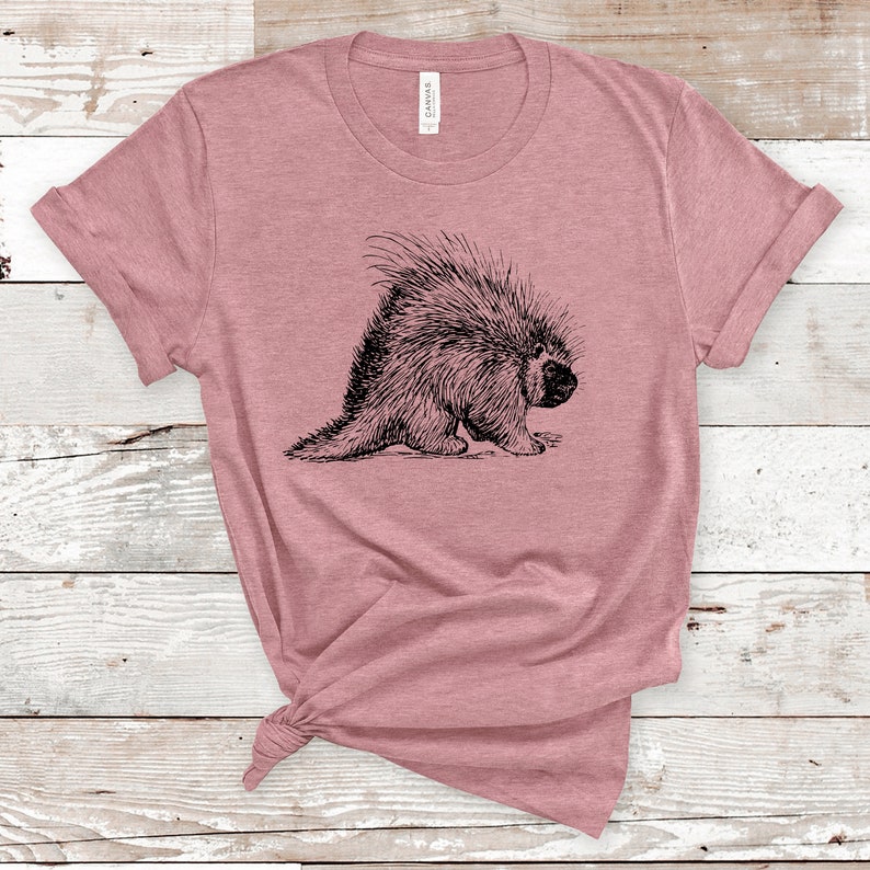 K&ouml;nnte beinhalten: Ein pinkfarbenes T-Shirt mit einer Schwarzwei&szlig;illustration eines Stachelschweins.
