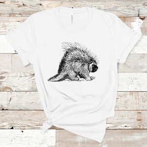 K&ouml;nnte beinhalten: Ein wei&szlig;es T-Shirt mit einer Schwarzwei&szlig;-Zeichnung eines Stachelschweins auf der Vorderseite.