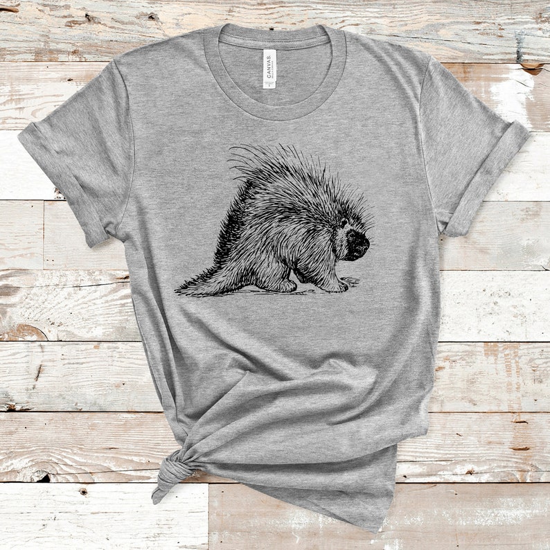 K&ouml;nnte beinhalten: Ein graues T-Shirt mit einer schwarz-wei&szlig;en Illustration eines Stachelschweins auf der Vorderseite.