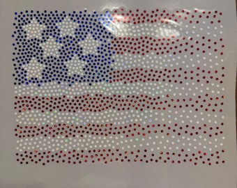 May include: A patriotic design featuring the American flag, rendered in sparkling red, white, and blue rhinestones. The flag's stars and stripes are meticulously crafted with the shimmering stones, creating a dazzling effect. The design is set against a neutral background.