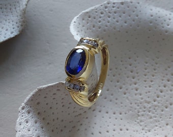 Blue sapphire 0.95ct and diamond 0.15ct ring set in 14K yellow gold with twisted shank detail.  UK size L.