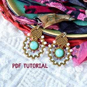 May include: A pair of handmade earrings with a turquoise stone and brown and white macrame. The earrings are on a white lace background with a pink and black fabric in the background. The text "PDF TUTORIAL" is printed in red on the image.