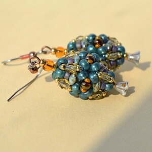 Delicati orecchini di perline con piccoli fiori nella parte inferiore