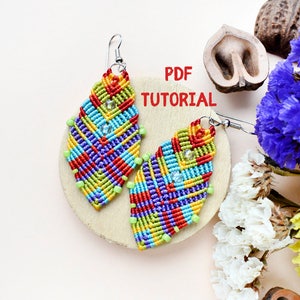 May include: A pair of colourful, geometrically patterned earrings with a PDF tutorial. The earrings are made with a variety of colours, including red, orange, yellow, green, blue, and purple. The earrings are hanging from silver hooks.