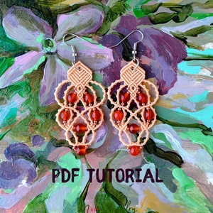 May include: A pair of peach-colored macrame earrings with red beads and silver hooks. The earrings are on a painted background with flowers. The text "PDF TUTORIAL" is at the bottom of the image.