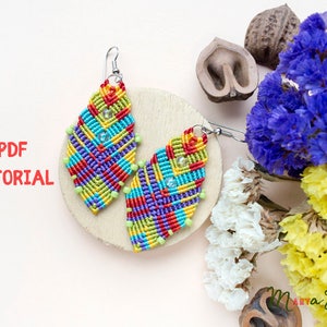 May include: A pair of colourful, geometrically patterned earrings made with macrame. The earrings are on a wooden surface with dried flowers in the background. The text "PDF TUTORIAL" is visible in the image.
