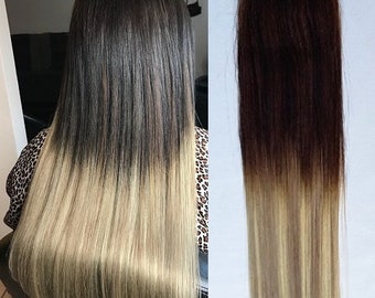 May include: Two wefts of dark brown to light blonde ombre human hair extensions. The wefts are straight and have a natural shine.