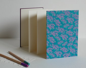 Accordion photo album, 12.5x17.5 cm, 14 white pages. Nepalese paper, small purple flowers on a turquoise background
