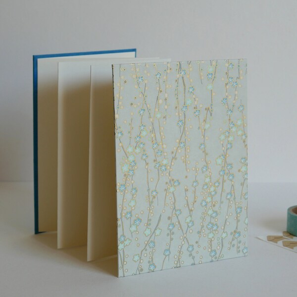 Album Fleurs de Cerisier, album photo accordéon bleu et doré, papier japonais. 12,5 x 17,5 cm, 14 pages blanches.