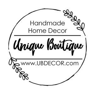 May include: Black and white logo with a circle border and floral accents. The text reads "Handmade Home Decor Unique Boutique www.UBDECOR.com"