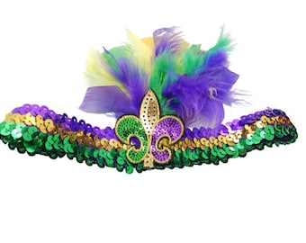 May include: Purple, green, and gold Mardi Gras headband with a sequined fleur-de-lis and feathers.