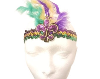 May include: Purple, green, and gold Mardi Gras headband with a sequined fleur-de-lis and feathers.