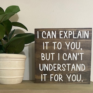 May include: A brown wooden sign with white text that reads "I can explain it to you, but I can't understand it for you."