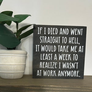 May include: A black wooden sign with white text that reads "IF I DIED AND WENT STRAIGHT TO HELL, IT WOULD TAKE ME AT LEAST A WEEK TO REALIZE I WASN'T AT WORK ANYMORE."