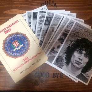 May include: A brown wooden surface with a stack of papers on it. The papers are black and white and have text on them. The text includes the words "Authorized Personnel Only", "Department of Justice", "Federal Bureau of Investigation", "FBI", "Classified Investigation File", "Case", "Date", "Mystery Terror", "It's Me", "Night Stalker", "Support Abused", "Face of Evil", "Ouija", "The Great River", "Dairy", "So", "Yes", "No", and "Good Bye".
