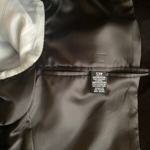 May include: A black blazer with a satin lining and a size tag that reads "$38", "SEA", "80% POLYESTER", "20% RAYON", "100% POLYESTER", "EXCLUSIVE OF DECORATION", "MADE IN VILTNAM", "WPL 8046".