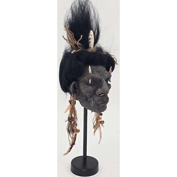 A hand-sculpted shrunken head replica that looks like it escaped a Victorian curiosity cabinet — unsettling in the best possible way.