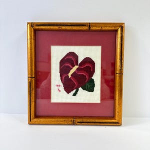 Vintage cross-stitch anthurium houseplant with gold bamboo frame, dated 1981