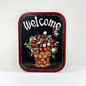 Panneau de bienvenue vintage avec des fraises peintes à la main dans un panier sur une plaque en bois noir