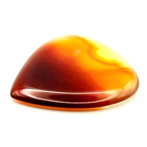 Puede incluir: Una gema triangular pulida con un degradado de colores. La piedra pasa de un marrón profundo y rico en la base a tonos vibrantes de naranja y amarillo en la parte superior. La superficie es lisa y reflectante, sobre un fondo blanco limpio.