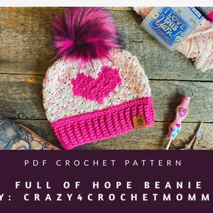 May include: A crochet beanie pattern for a pink and white beanie with a heart design. The pattern is called "Full of Hope Beanie" by "Crazy4CrochetMomma".