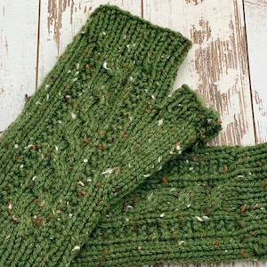 May include: A pair of green knitted fingerless gloves with a speckled pattern. The gloves are made with a chunky yarn and have a cable knit design.