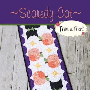 May include: A quilted Halloween-themed table runner featuring a black cat with a green bow tie, orange pumpkins, and yellow stars on a white background. The text "Scaredy Cat" and "This & That" are visible. The pattern number is #348.