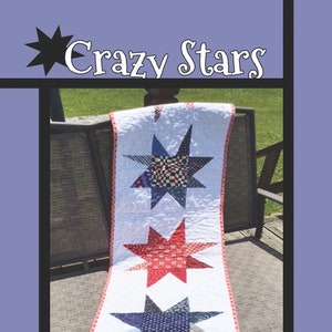 May include: A table runner with a "Crazy Stars" design featuring three stars made of patchwork fabric in red, white, and blue. The runner is on a wooden chair with a woven back. The text "Tricia Lynn Maloney Orphan Quilt Designs For Villa Rosa Designs" is at the bottom of the image.