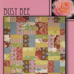 May include: A quilt pattern called "Busy Bee" with a patchwork design featuring various floral and geometric patterns in shades of pink, yellow, green, blue, and brown. The quilt pattern is from Villa Rosa Designs.