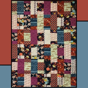 May include: A patchwork quilt titled "Brickwork" with a variety of floral and geometric patterns in shades of red, blue, purple, and cream. The quilt is made by Molly Cook for Villa Rosa Designs. The background is red and blue.